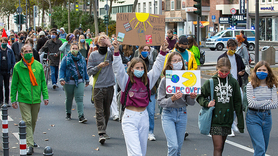 Fridays-for-Future-Demonstration mit Schülerinnen die Schilder halten im Vordergrund 