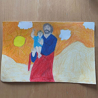 Ein Bild zeigt Josef als liebenden Vater, der Jesus auf den Arm hält. 